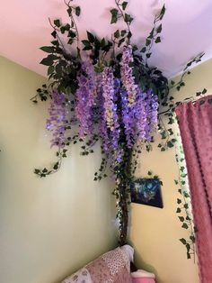 purple flowers hanging from the ceiling in a bedroom