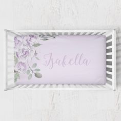 a baby's name is placed in the crib with purple flowers on it