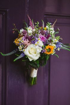 a bouquet of flowers sitting on top of a purple door