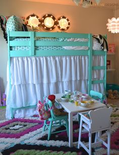 a child's room with a bunk bed, table and chair set up in front of it