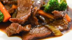 beef, broccoli and carrots on a white plate