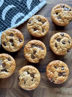 chocolate chip cookies on a cutting board next to a towel