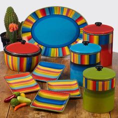 brightly colored dishes and containers on a wooden table with cacti in the background