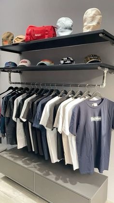 a clothing rack with shirts and hats on it