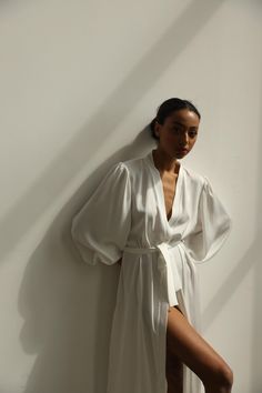 Our long bridal silk robe with wide long sleeves. It could be made of satin or pure mulberry silk. The robe is both casual and elegant, you may wear it on the hen party or spontaneously around your home on a daily basis. It is also an amazing outfit for your vocation, to wear it on the beautiful beach or by the pool as a cover up. -Our model wears size XS, her measurements are 82/61/87 cm and she is 172 cm tall. -Attached with belt. -Arrives beautifully packaged in tissue paper with ribbon -Leng Elegant V-neck Robe For Daywear, Elegant V-neck Kimono For Wedding, Elegant Silk Summer Robe, Elegant Summer Silk Robe, Elegant V-neck Wedding Kimono, Elegant Robe For Wedding Night In Spring, Elegant Wrap Sleepwear, Elegant Spring Wedding Night Robe, Wedding Robe With Kimono Sleeves For Spring