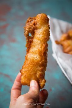 a person holding up a fried food item in their hand