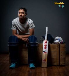 a man sitting on top of a wooden crate next to a cricket bat and ball