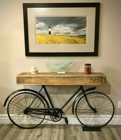 a bike is parked in front of a painting on the wall and under a table