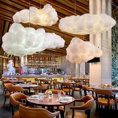 a restaurant with tables, chairs and hanging clouds