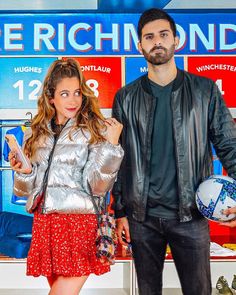 a man and woman standing in front of a store