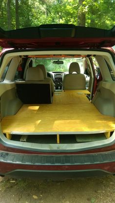 the back end of a car with an open trunk and table in it's cargo area