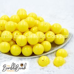 a white plate filled with yellow candies on top of a white table covered in fur