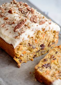 a loaf of carrot cake with frosting and pecans