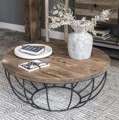 a coffee table with flowers in a vase on top and magazines on the bottom shelf