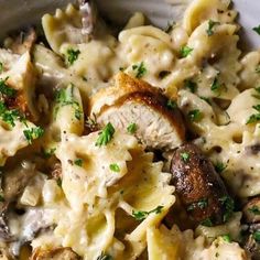 a bowl filled with pasta and meat covered in sauce