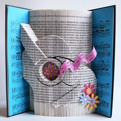 an open book that has some paper on it and is decorated with scissors, tape and flowers