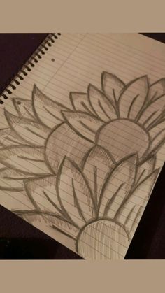 a drawing of a flower is shown on a piece of paper with graphite pencils