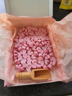 pink marshmallows in a baking pan with a wooden spatula