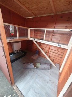 the inside of a chicken coop with wooden walls and flooring on top of it