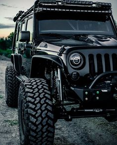 a black jeep parked on top of a dirt road