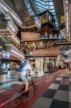 a man riding a bike through a shopping mall