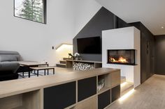 a living room filled with furniture and a fire place next to a wall mounted tv