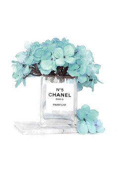 a chanel perfume bottle with blue flowers in it