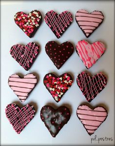 heart shaped cookies decorated with pink, black and white icing are arranged in a grid pattern