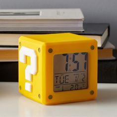 a yellow alarm clock sitting on top of a table