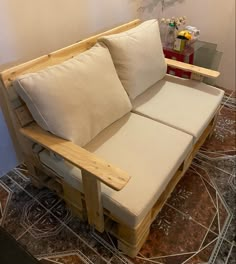 a couch made out of wooden pallets with white pillows