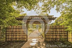 an open wooden gate in the middle of a park