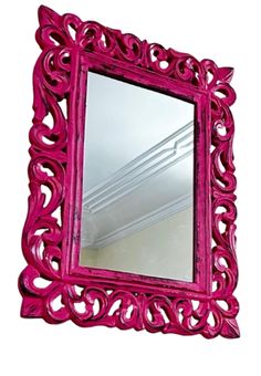 a pink mirror sitting on top of a white wall