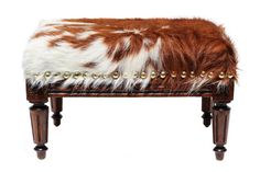 an animal print bench with gold studdings and fur on the top, against a white background