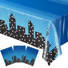 a blue table cloth with black and white dots on it, in front of a cityscape backdrop