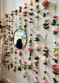 the wall is covered with flowers and has a mirror hanging on it's side