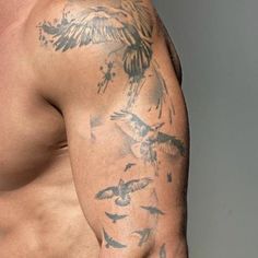 a man with tattoos on his arm and chest