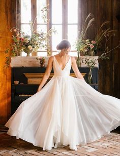 a woman in a white dress standing next to a piano