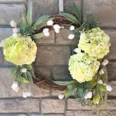 a wreath with flowers hanging on a brick wall