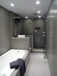 a bathroom with a bathtub, sink and shower in it's center area