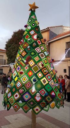 a crocheted christmas tree is on display outside