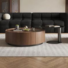 a modern living room with black couches and coffee table in front of the sectional sofa