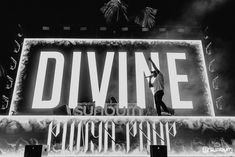 a man standing on top of a stage with his arms in the air