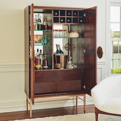 an armoire with liquor bottles and glasses on it