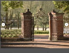 an iron gate with two birds sitting on top of it and surrounded by brick pillars