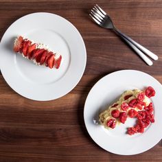 two white plates topped with slices of cake and strawberries