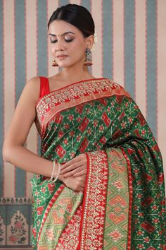 Royal green Patola silk saree with red gota embroidery border is a perfect drape for festive occasions! It comes with a matching blouse piece. Disclaimer: The actual product may vary slightly from the image. These are custom orders, hence expect slight variation in color, placement of the motif or buta. ESTIMATED DELIVERYBecause this is a custom order, it would take about 4 weeks from the date of purchase. RETURN POLICYThis product is a custom order and cannot be returned or exchanged. Green Pre-draped Saree With Meenakari For Puja, Festive Green Paithani Silk Pre-draped Saree, Green Bollywood Pre-draped Saree With Meenakari, Traditional Green Meenakari Blouse Piece, Green Meenakari Blouse Piece For Puja, Traditional Green Blouse With Meenakari, Green Blouse Piece With Meenakari For Puja, Traditional Green Embroidered Pre-draped Saree, Traditional Embroidered Green Pre-draped Saree