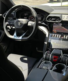 the interior of a car with dashboard, steering wheel and display screen showing various electronic devices