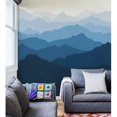 a living room with mountains painted on the wall