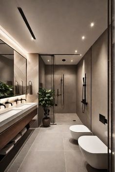 a modern bathroom with two toilets and a plant in the corner