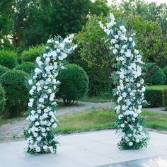 two white flowers are in the shape of an arch